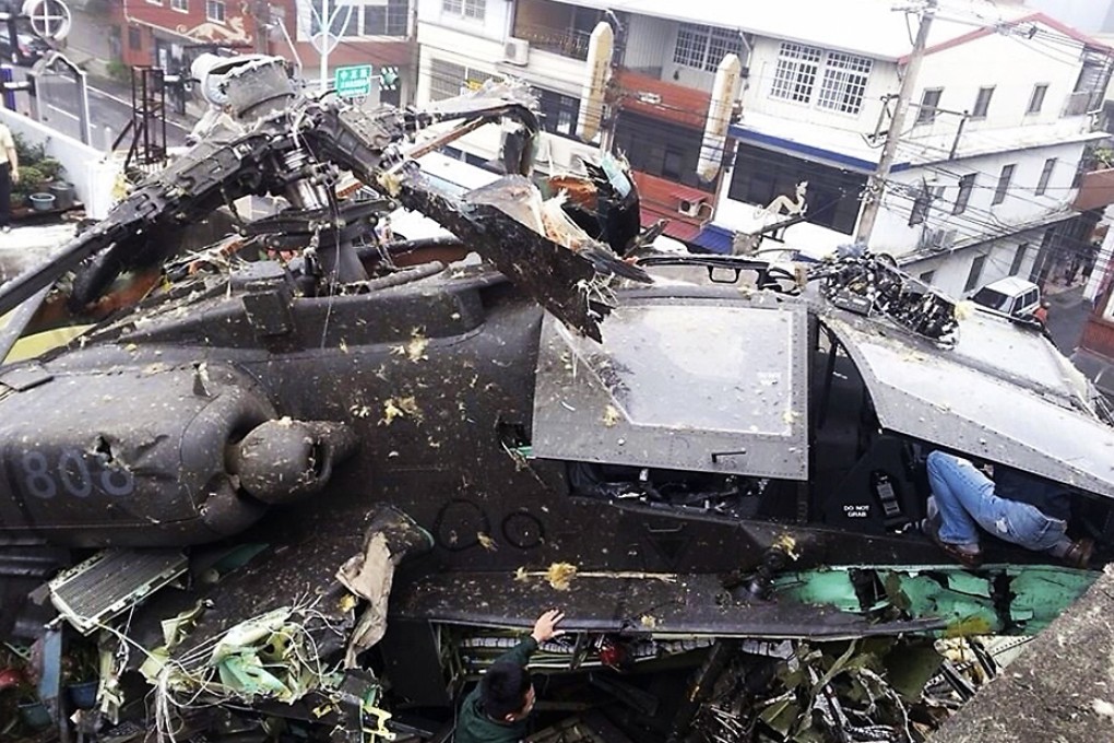An AH-64E Apache attack helicopter purchased from the U.S. is seen crashed on top of an apartment in Taoyuan County, northern Taiwan, April 25, 2014. Photo: Reuters