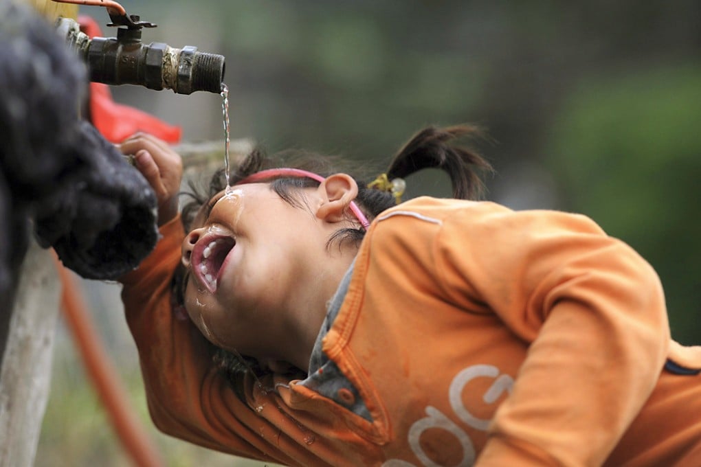 A girl drinks from a tap in Anhui. The Wuhan government said one of two water plants in the city had resumed operations this morning. Photo: Reuters