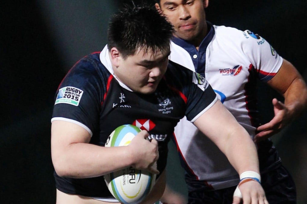 Leon Wei Hon-sum tries to fight off a Filipino defender during Hong Kong's win in the Asian Five Nations. Photo: Jonathan Wong/SCMP