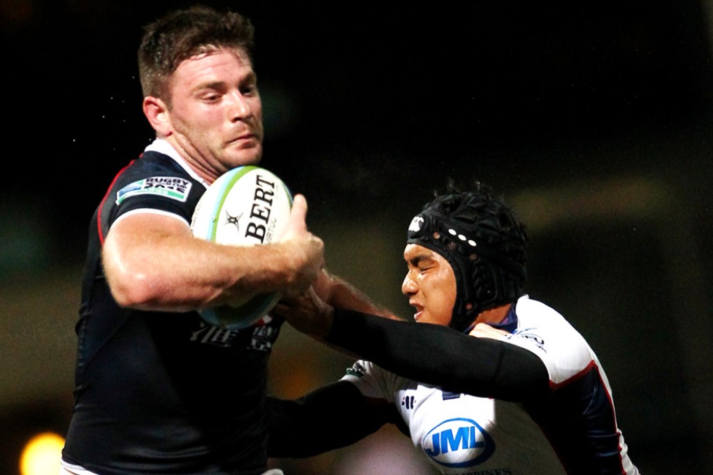 Tom McColl powers past Rupert Zappia of the Philippines to score one of 16 Hong Kong tries in their 108-0 Asian Five Nations win on Saturday. Photo: Jonathan Wong/SCMP