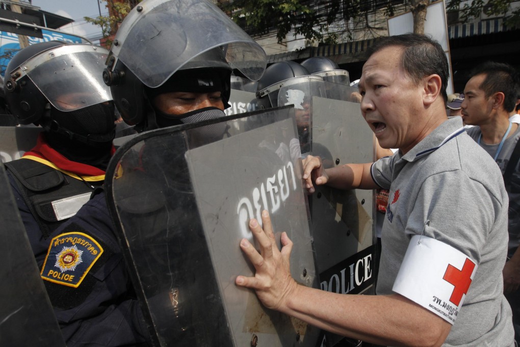 Thai riot police and anti-government protesters in Bangkok. Authorities have made a rare arrest of one of the leaders of the country’s anti-government protest movement. Photo: Reuters