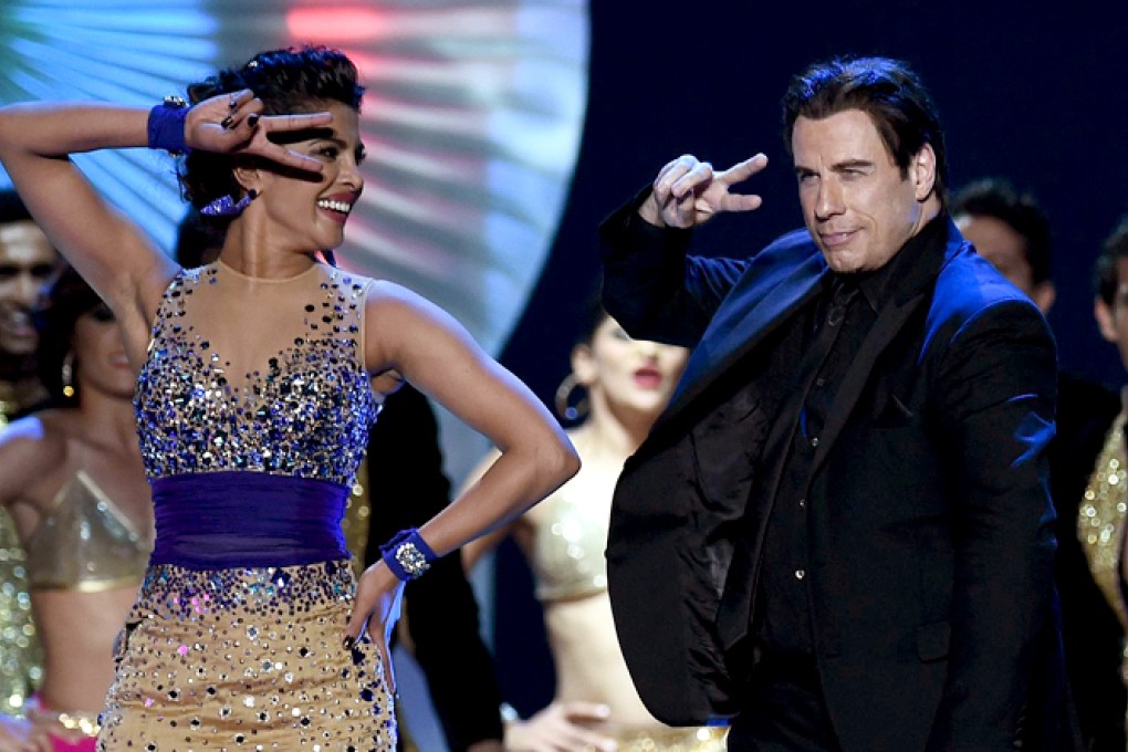 Bollywood actress Priyanka Chopra dances with Hollywood actor John Travolta on stage during the final day of Iifa awards. Photo: AFP