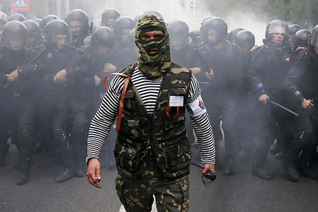 A pro-Russian activist walks in front of Ukrainian riot police during a pro-Ukrainian rally in the eastern city of Donetsk as tensions between the sides continue. Photo: Reuters
