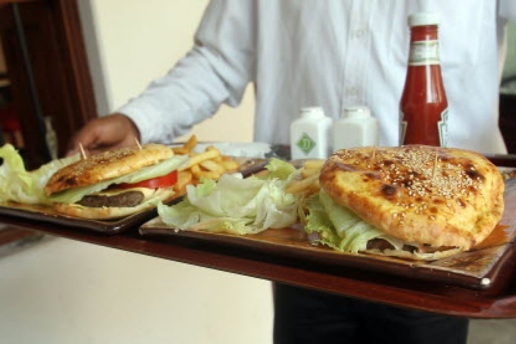 A waiter serves camel burgers at the Local House restaurant in Dubai. Camel meat is eaten throughout the Gulf. Photo: AFP