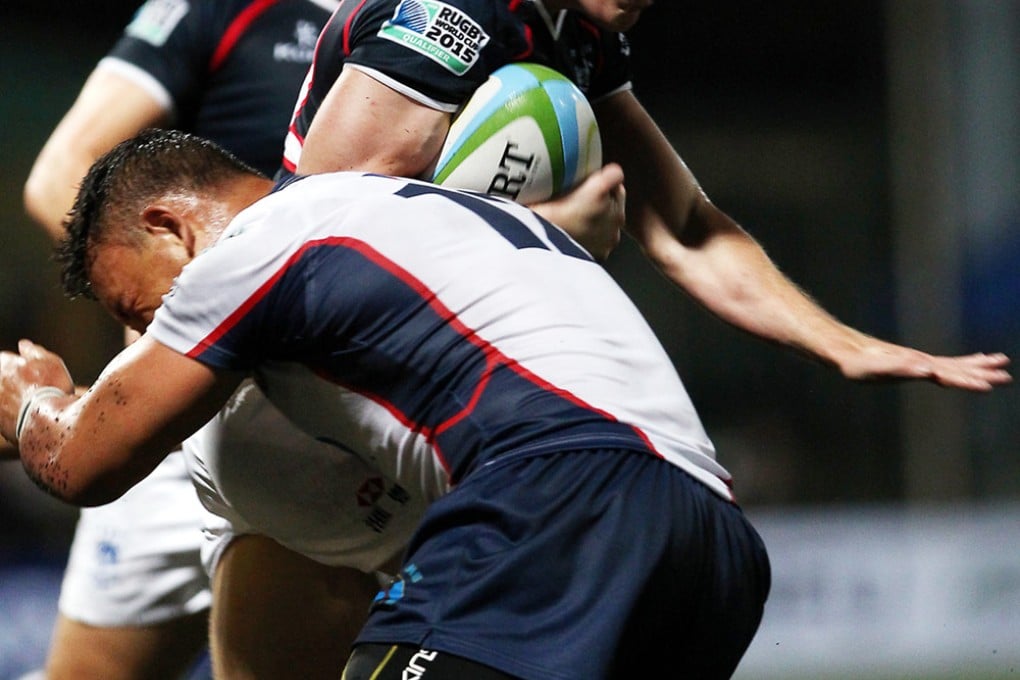 Class of ’14 full-back Nick Wheatley is tackled by Justin Coveney of the Philippines during Hong Kong’s 108-0 victory on Saturday. Photo: Jonathan Wong/SCMP