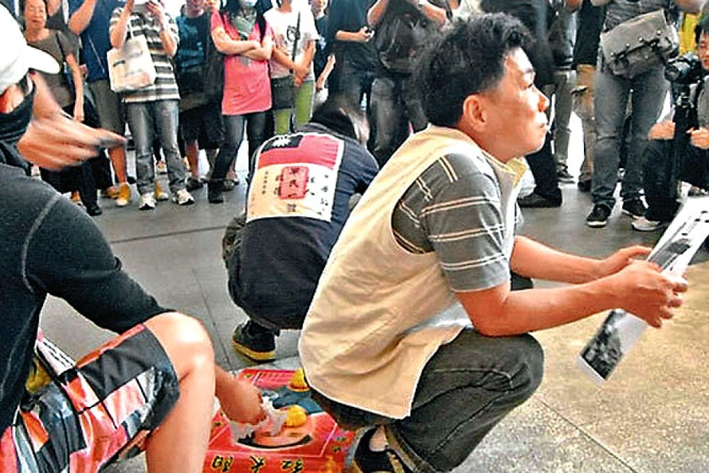 About 30 Hongkongers mocked mainland tourists by mimicking their toddlers defecating and placing fake faeces under them in Harbour City. Photo: SCMP Pictures