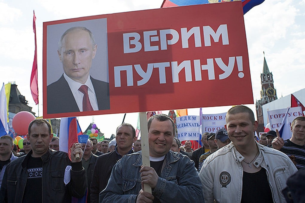 Muscovites march on May Day. The placards read: 'We Believe in Putin' (foreground) and 'We will spend our vacation in Crimea', (background). Photo: AP