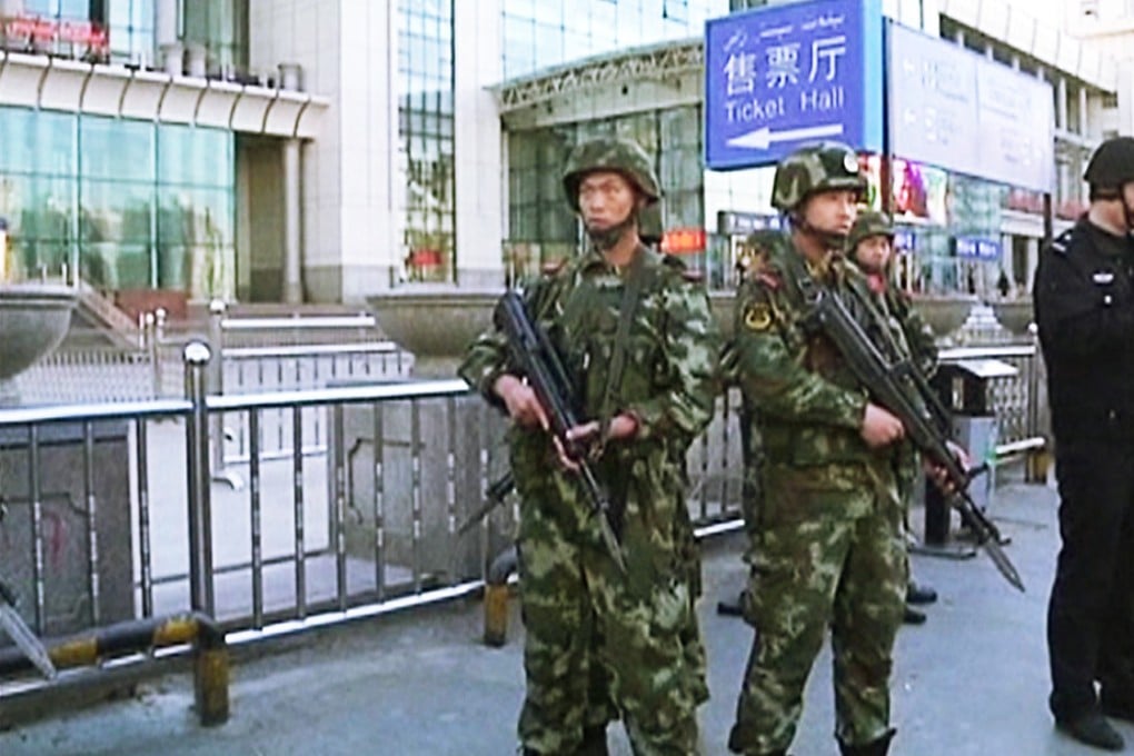 Armed police officers standing guard at the Urumqi South railway station. Photo: Reuters