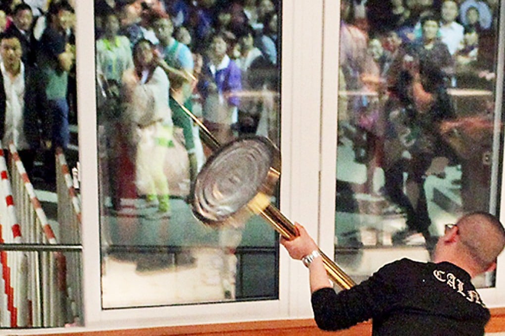 A man tries to smash a window at the tourism office of Xiang Lake in Hangzhou. Photo: Weibo