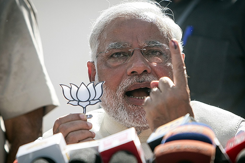 Narendra Modi flashes his party symbol and makes a speech after casting his ballot at a polling booth in Ahmedabad, capital of Gujrat. Photo: Xinhua