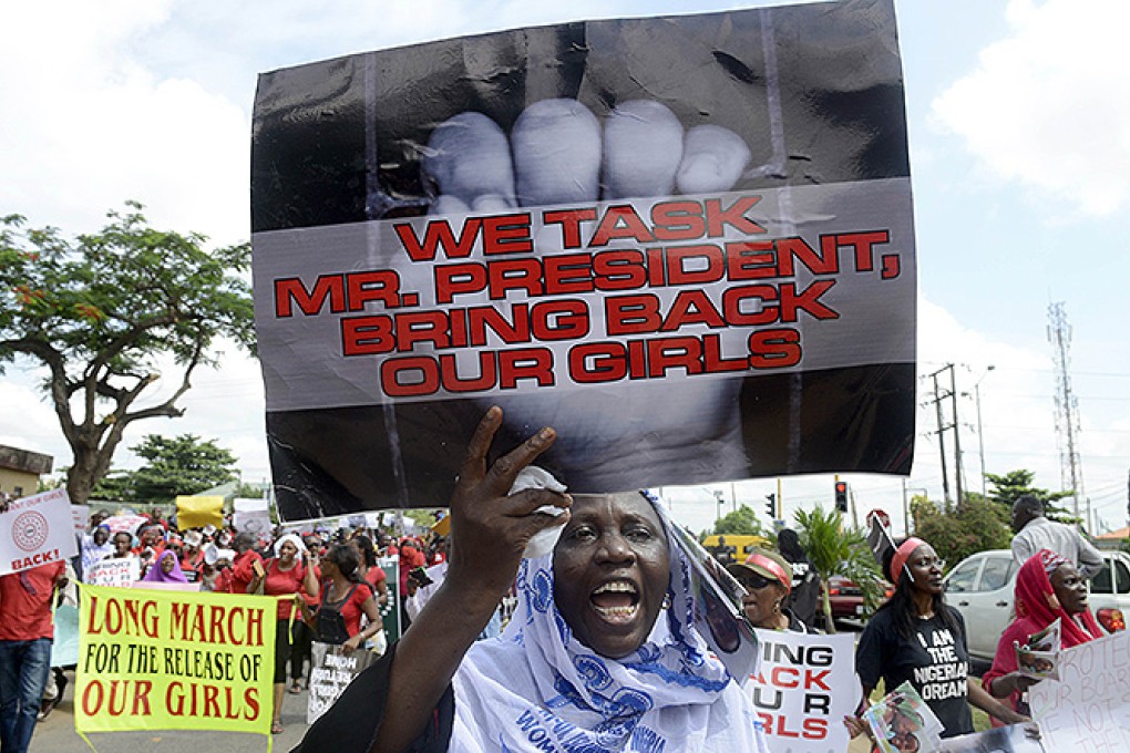 A woman holds a sign as members of Lagos based civil society groups hold rally calling for the release of missing Chibok school girls at the state government house in Lagos. Photo: AFP