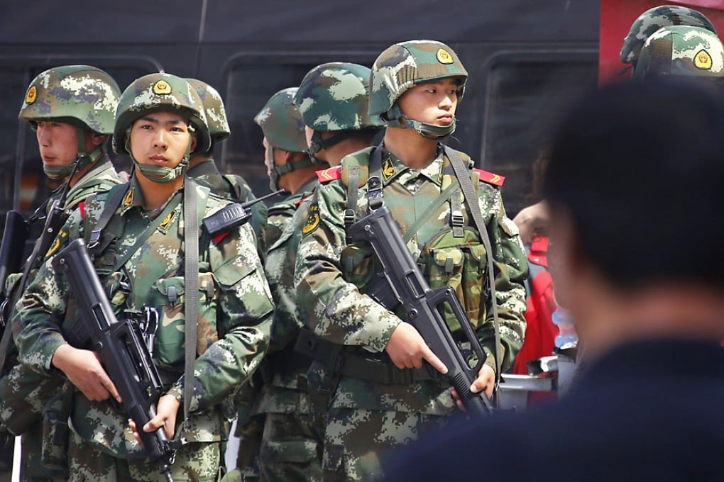 Paramilitary police stand guard outside the main railway station in Urumqi after last week's attack. Photo: Reuters