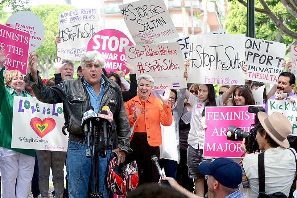 US television personality Jay Leno addressing banner-waving human rights protesters in Beverly Hills. Photo: AFP