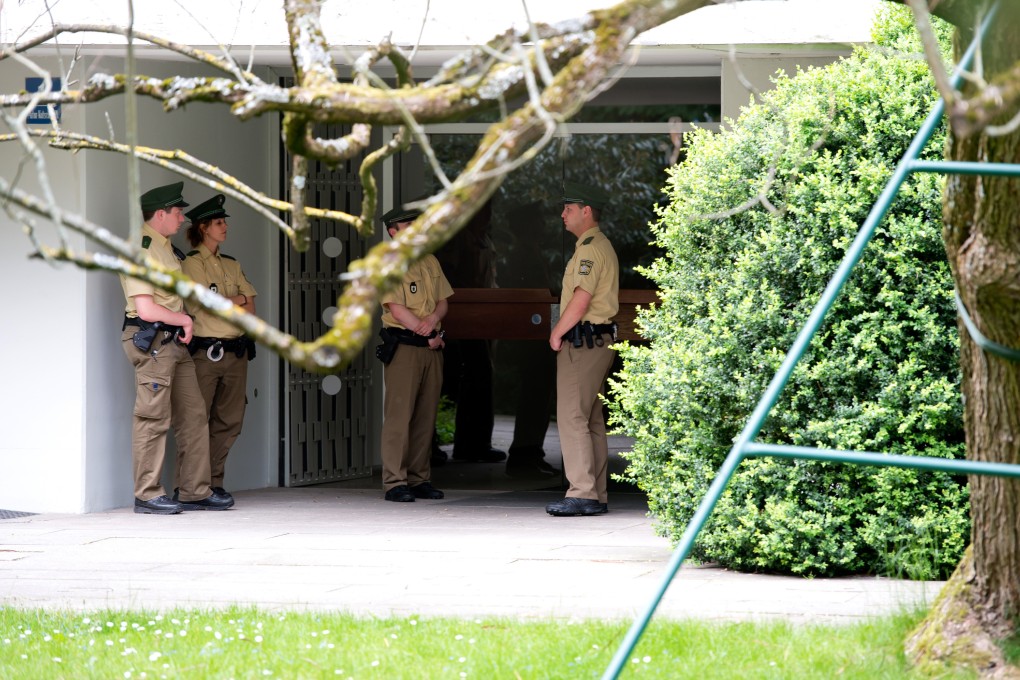 Police officers stand in front of a house where art collector Cornelius Gurlitt lived. Photo: AP