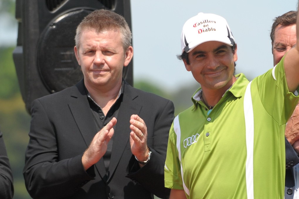 Asian Tour chief executive Mike Kerr at the trophy presentation next to winner Felipe Aguilar of Chile during the Championship at Laguna National in Singapore. Photo: AFP