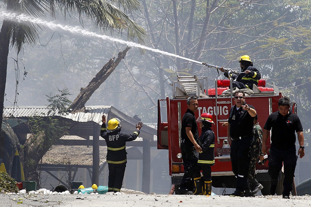 Firemen at the scene of the explosion at Fort Bonifacio, Taguig City. Photo: EPA