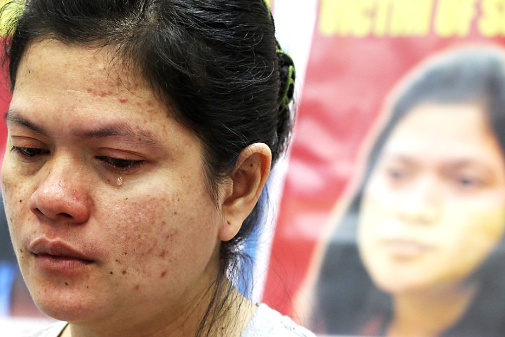 Filipino helper Rowena Uychiat, in front of a poster of Erwiana Sulistyaningsih, claimed she had been abused by her employer since arriving in Hong Kong last July. Photo: Edward Wong