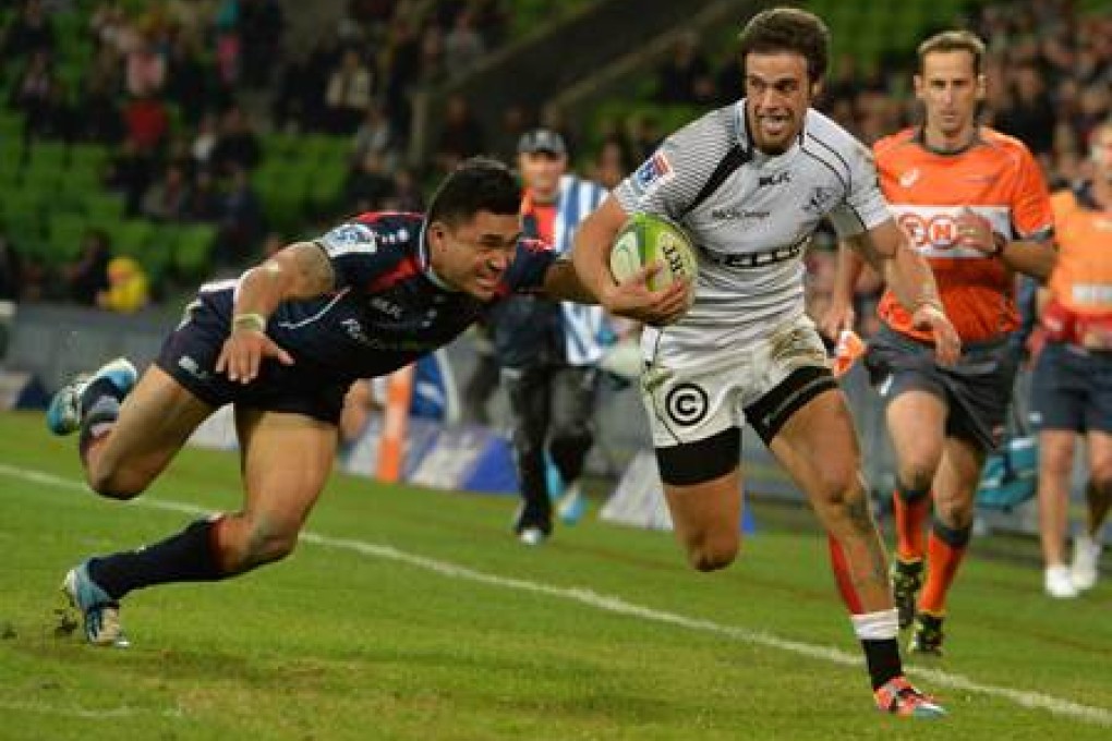 Sharks inside centre Heimar Williams tries to evade Rebels wing Male Sa’u in their Super 15 clash in Melbourne last Friday – a match the Sharks won 22-16. Photo: AFP