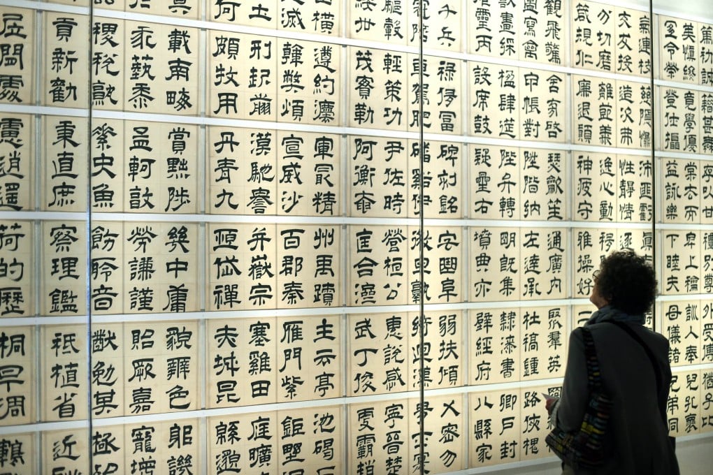 A woman looks at traditional Chinese calligraphy. Mainland China, Japan and South Korea will jointly release a standardised list of the 808 most widely used Chinese characters in the three countries. Photo: AFP