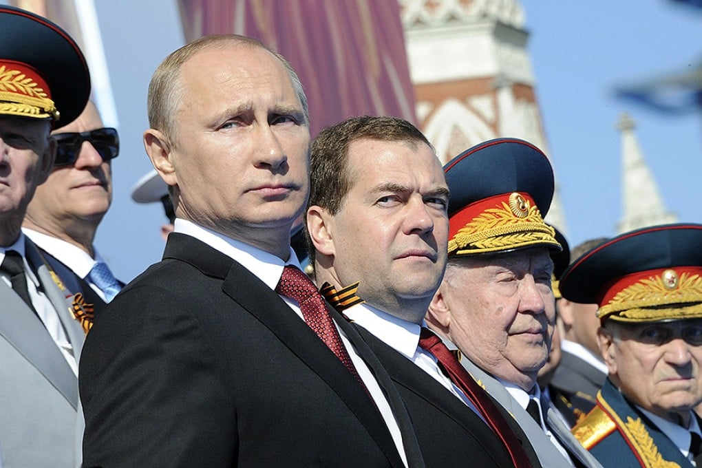 President Putin and Prime Minister Medvedev watch the Victory Day parade in Red Square. Photo: Reuters