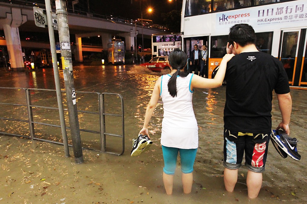 A couple walk through floodwater at Leighton Road in Causeway Bay during the Black Rainstorm. Photo: Edmond So