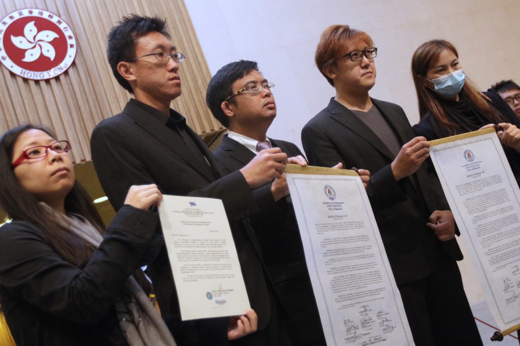 Survivor Lee Ying-chuen, deceased tour guide Masa Tse Ting-chunn's brother Tse Chi-hang, lawmaker James To Kun-sun, Tse's older brother Tse Chi-kin and survivor Yik Siu-ling with the resolutions from Manila city council and the letter from the police chief. Photo: Felix Wong