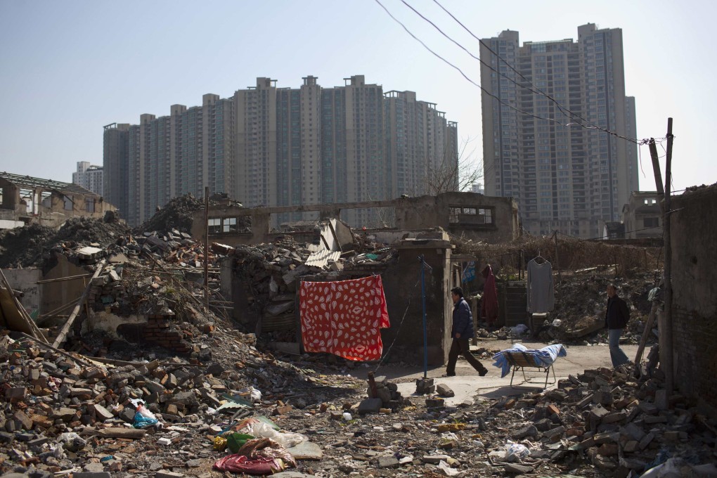 People walk in an area where residential buildings are demolished to make room for skyscrapers in Shanghai. Photo: Reuters