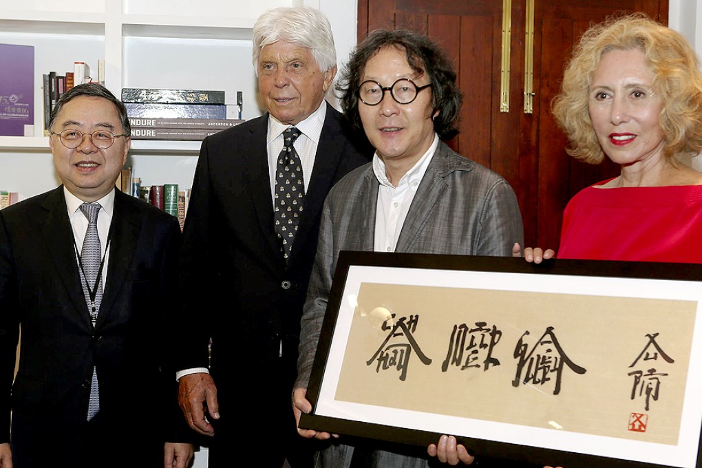 Asia Society Hong Kong Centre chairman Ronnie Chan Chi-chung (left) with artist Xu Bing (centre right), presenting a work to philanthropist Robert Miller and his wife Chantal yesterday. Photo: K.Y. Cheng