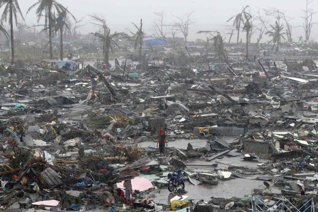 Devastation left by Super Typhoon Haiyan in Tacloban, with survivors stranded in the mud and rain amid debris from their homes against a bleak backdrop of wind-battered palm trees. Photo: Reuters