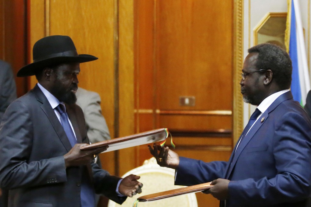 South Sudan's rebel leader Riek Machar (right) and South Sudan's President Salva Kiir exchange signed peace agreement documents in Addis Ababa. Photo: Reuters