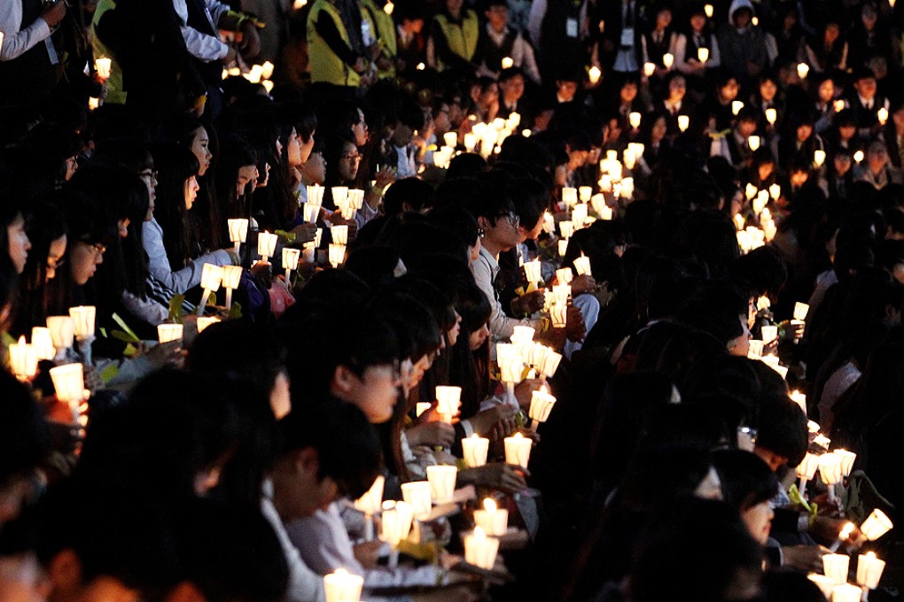 High school students hold candles during a rally to pay tribute to the victims and missing passengers of the sunken ferry Sewol in Ansan, South Korea on Friday. Photo: AP