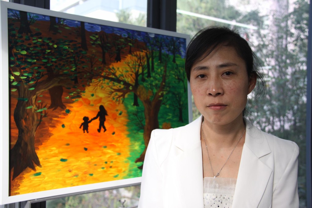 Zhang Jing stands in front of her son Qiangqiang's painting Leaving at the Centre for Community Development in Hong Kong. Photo: Sijia Jiang