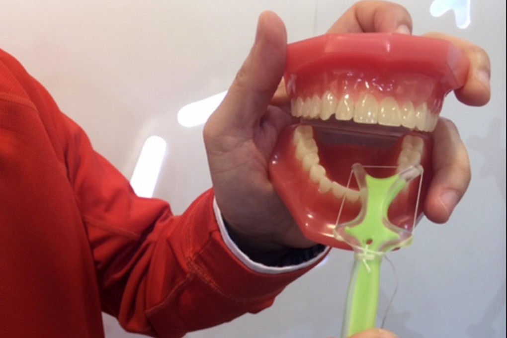 Gordon Lam demonstrates his flossing aid. Photo: Christy Choi