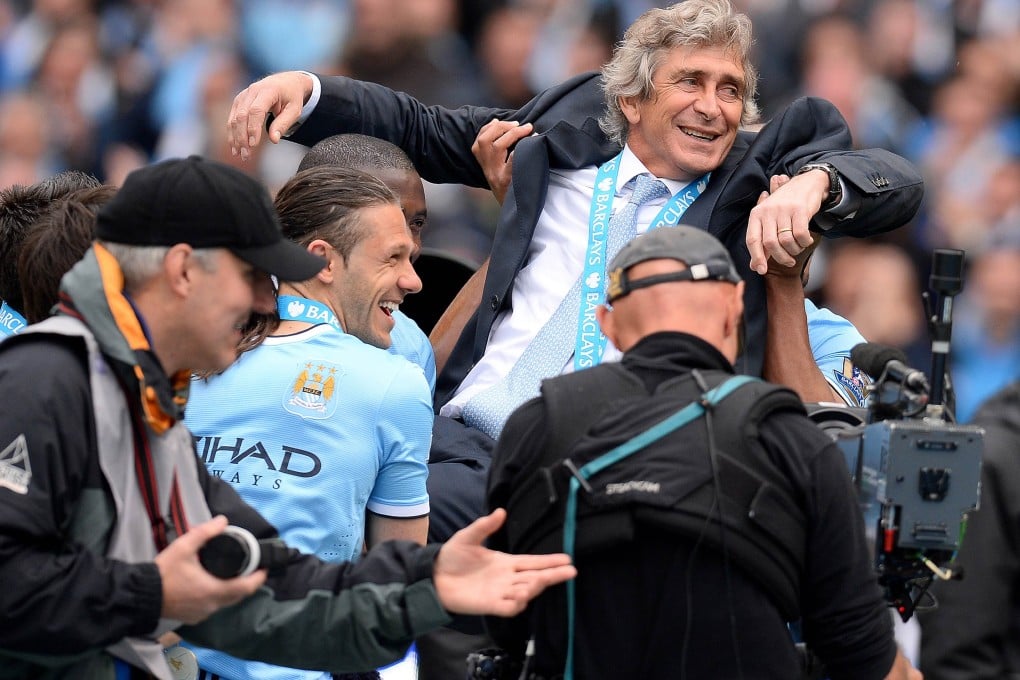 Manuel Pellegrini is thrown in the air by City's players. Photo: AFP