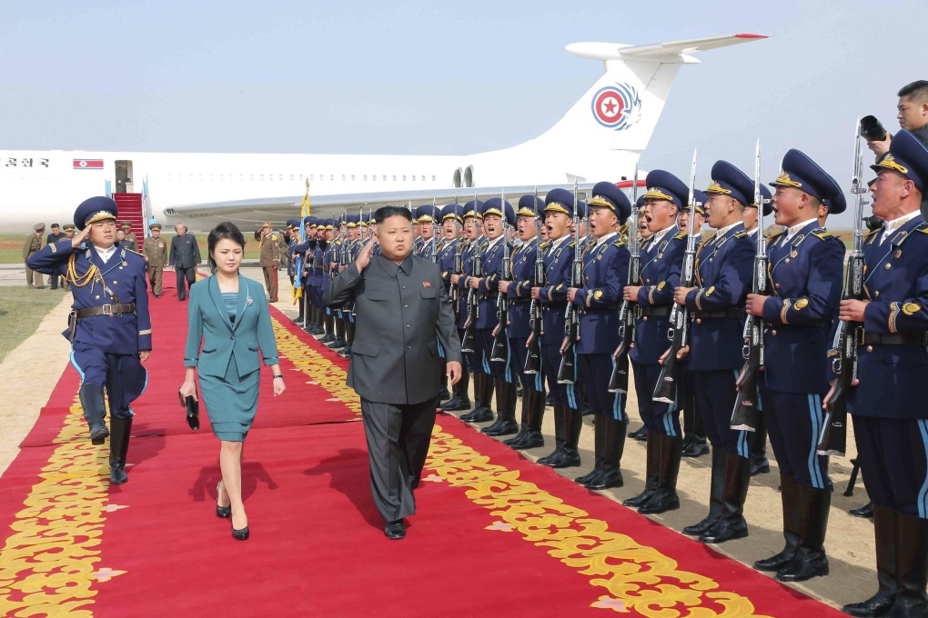 Kim Jong-un and his wife Ri Sol-ju walk past the guard of honour as they arrive for the 2014 Combat Flight Contest among commanding officers of the air force in this undated picture. Photo: Reuters