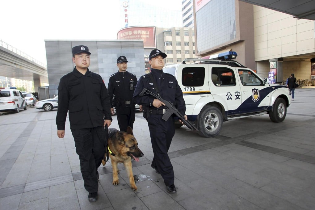 Armed officers and a police dog patrol in a business district of Beijing yesterday. A new unit of 2,000 officers in 150 armed patrol cars are beefing up security in the capital in the wake of a series of violent attacks in cities in recent months. Photo: Reuters