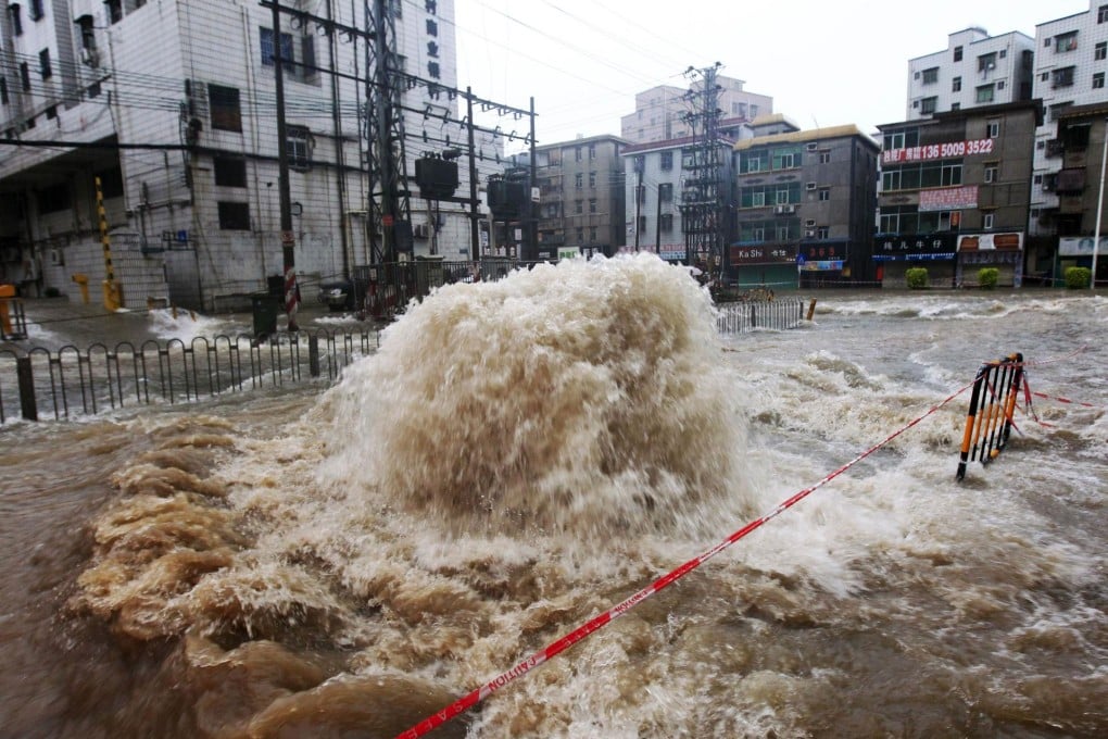 Flood water bursts onto a street from a sewer in Shenzhen. Photo: AFP