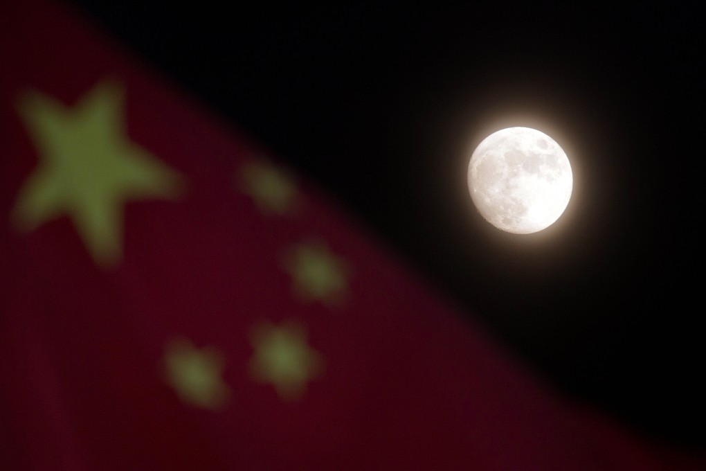 The moon is seen near a Chinese national flag in Beijing. Photo: AP