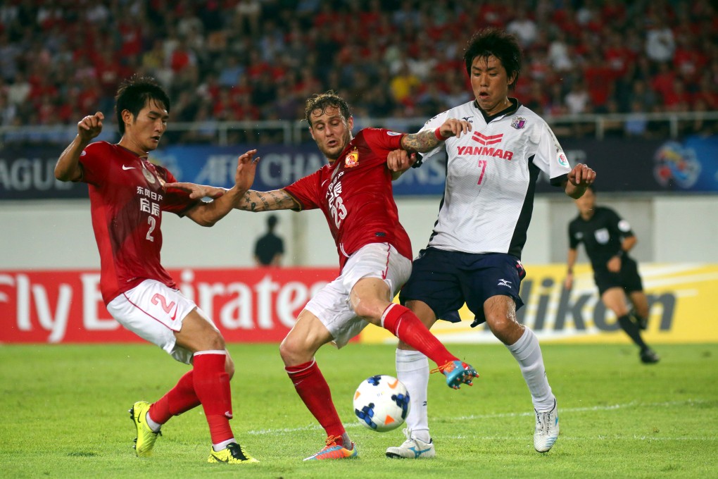 Guangzhou Evergrande's Italian playmaker Alessandro Diamanti and Liao Lisheng battle for the ball with Cerezo Osaka's Toru Araiba. Photo: Xinhua