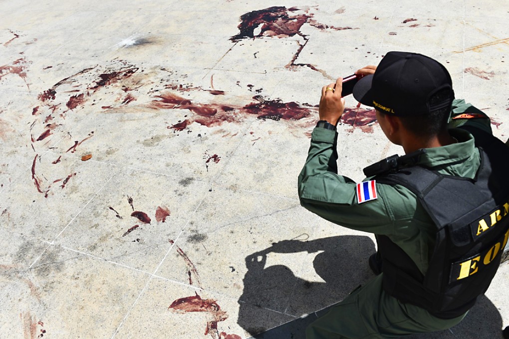 A soldier takes photos of the blood stains at an attack site near the Democracy Monument in Bangkok. Photo: Xinhua