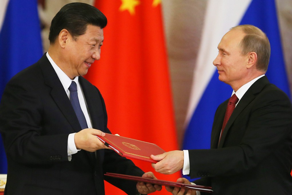 China's President Xi Jinping (left) and Russian President Vladimir Putin exchange signed document after their meeting in Moscow, Russia in 2013. Photo: EPA