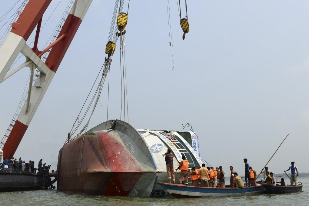 Rescue members inspect the capsized M.V. Miraj 4 ferry during a salvage operation at the Meghna river at Rasulpur in Munshiganj district. Photo: Reuters