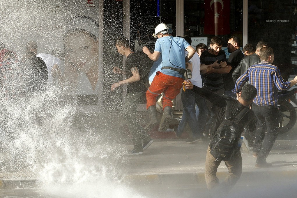 Protesters try to escape the jet of an advancing police water cannon during a protest on Friday against the government after the mine explosion in Soma. Photo: EPA
