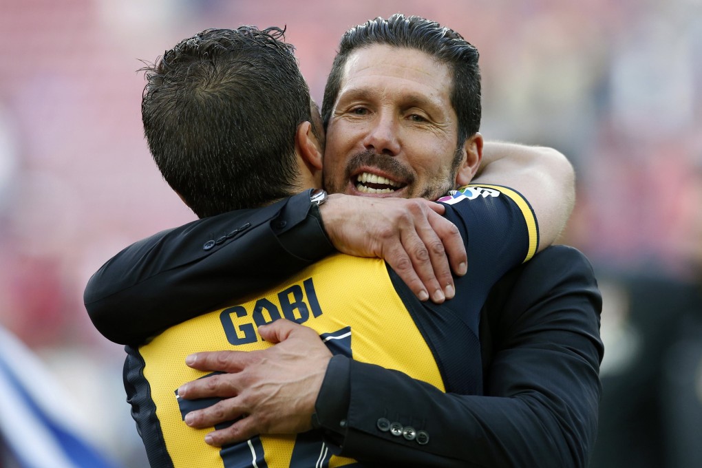 Atletico Madrid coach Diego Simeone  embraces captain Gabi after winning the Spanish Primera Liga. Photo: Reuters