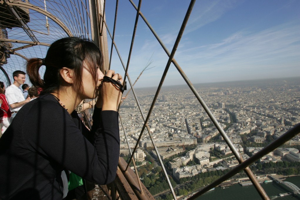 Chinese tourists take in the view over Paris from the Eiffel tower. The Department of Consular Affairs is struggling to cope with the surging number of Chinese nationals making overseas trips. Photo: AFP