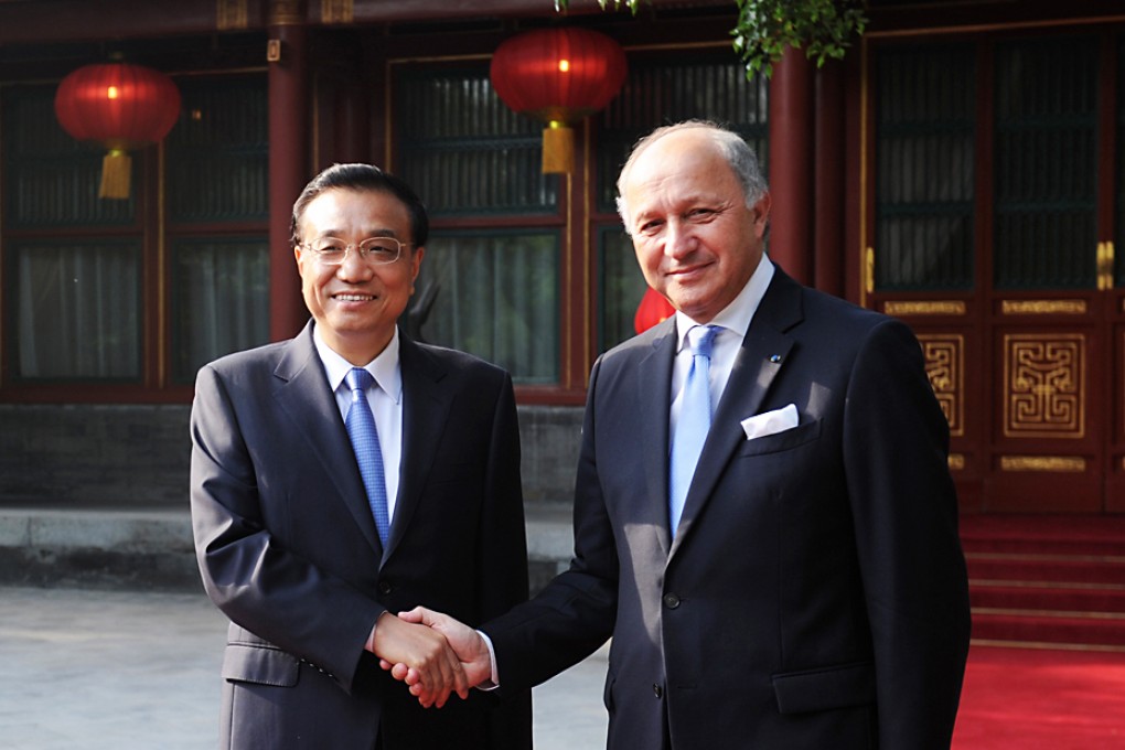 French Foreign Minister Laurent Fabius (right) and Chinese Premier Li Keqiang pose for photographers at Beijing's Diaoyutai state guesthouse in Beijing on May 19, 2014. Photo: AP