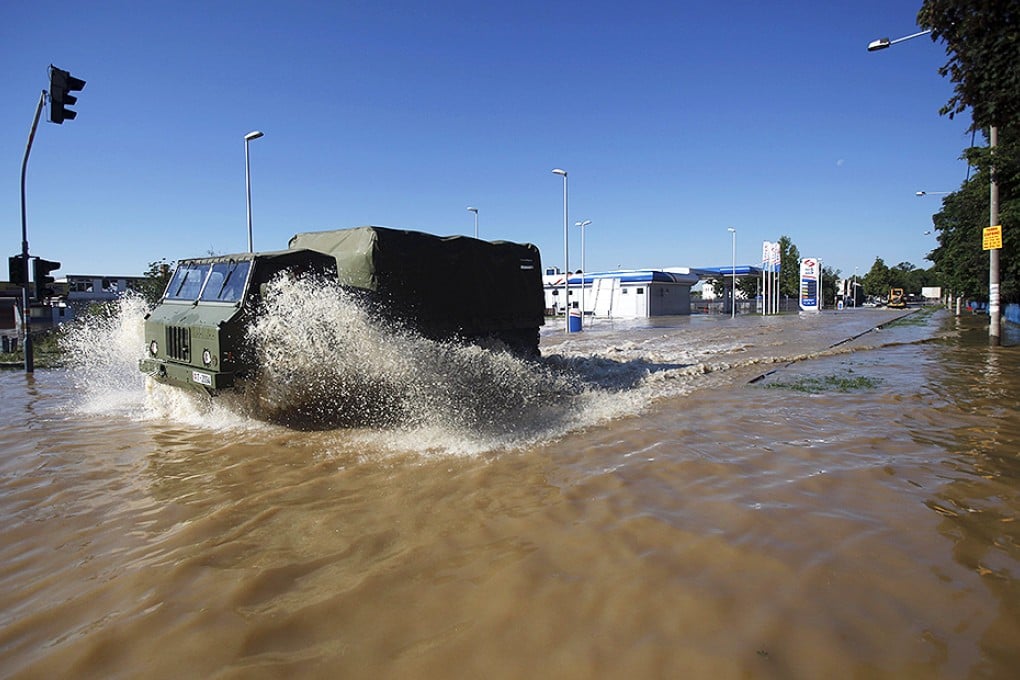 Serbian army trucks drive through flood waters in the town of Obrenovac. Photo: Reuters