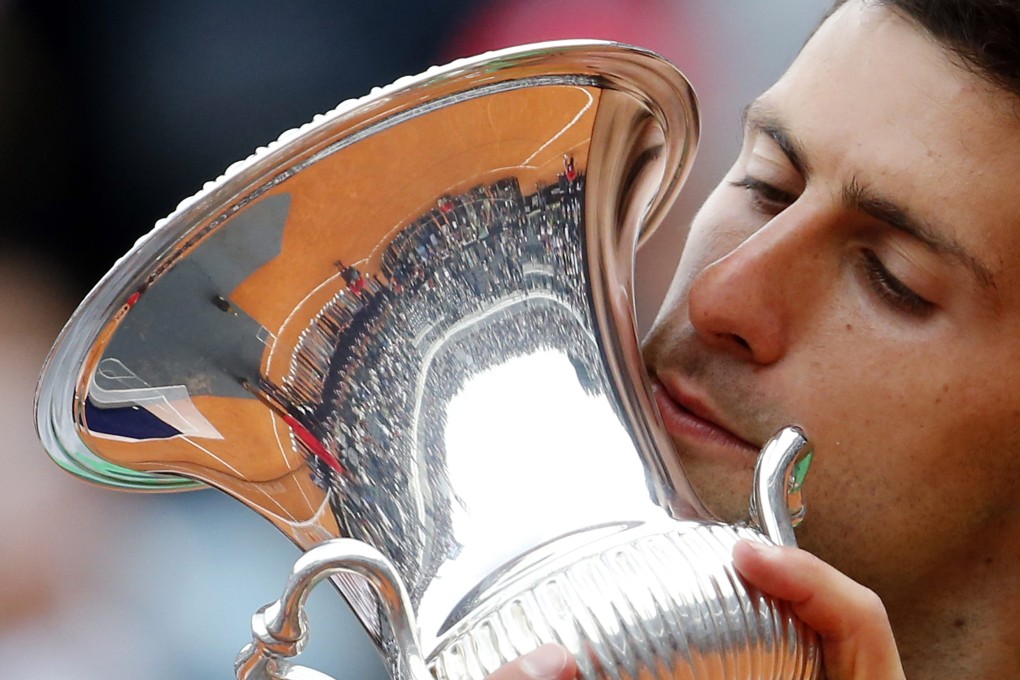 Novak Djokovic of Serbia kisses the trophy after winning the final. Photo: Reuters