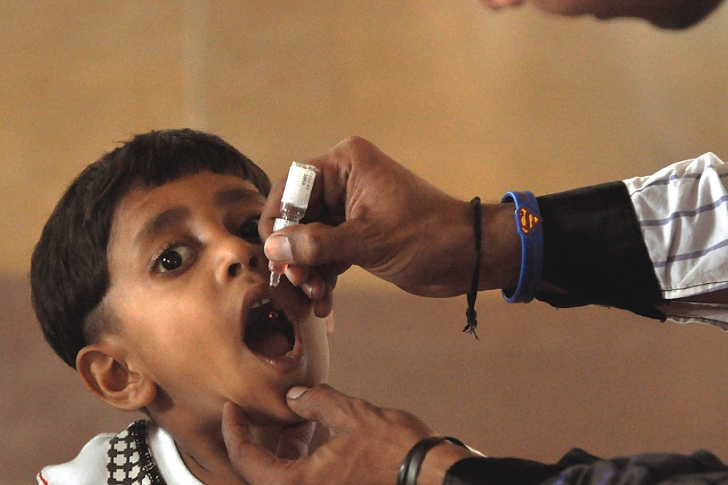 A health worker administers a polio vaccine to a child in Pakistan. Photo: EPA