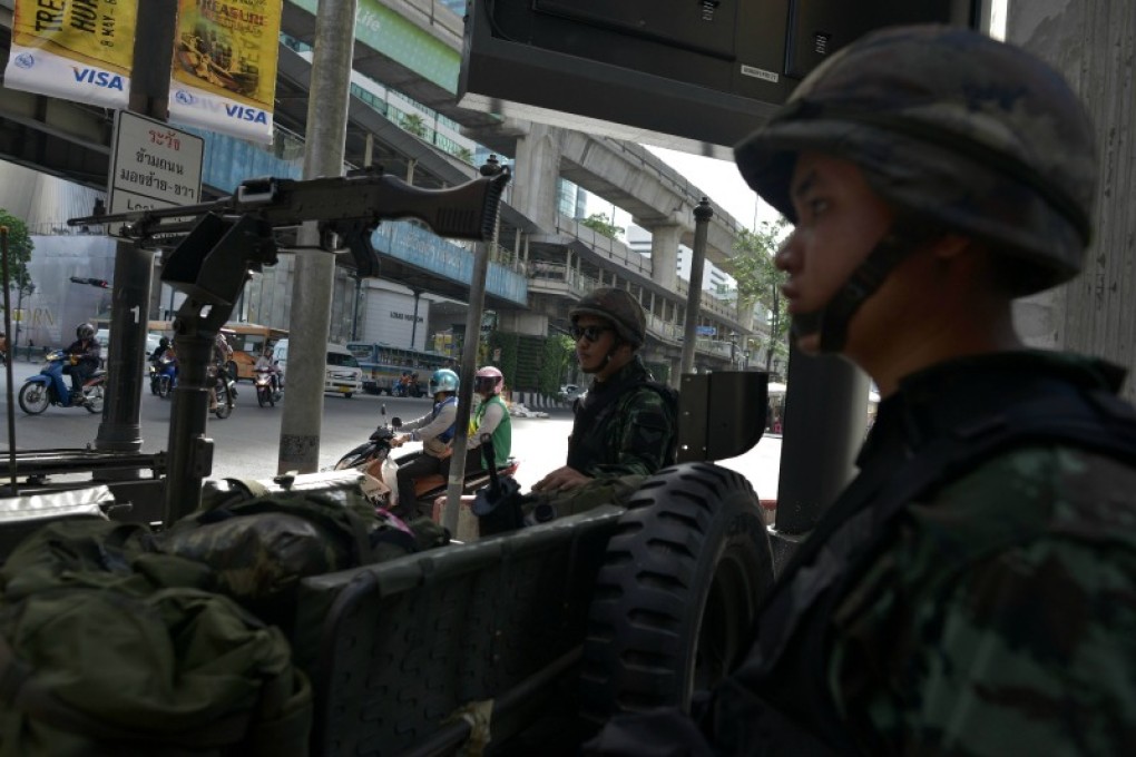 Thai army soldiers stand next to a jeep mounted with a machine gun in Bangkok on Tuesday. Photo: AFP